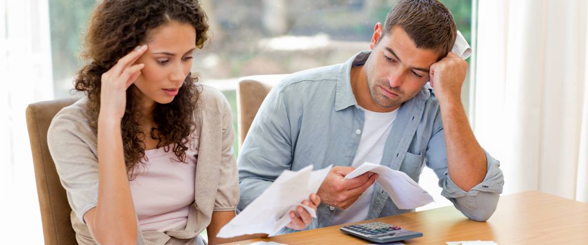 Young couple calculating their domestic bills at home.