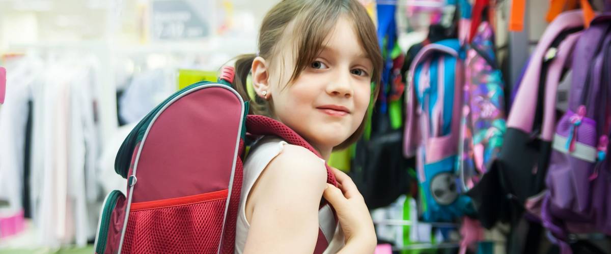 girl in store choosing briefcase for school.