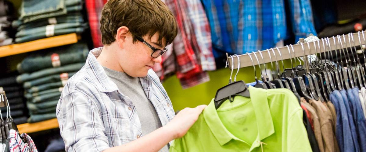 Teenager shopping for new clothes at the department stpre.