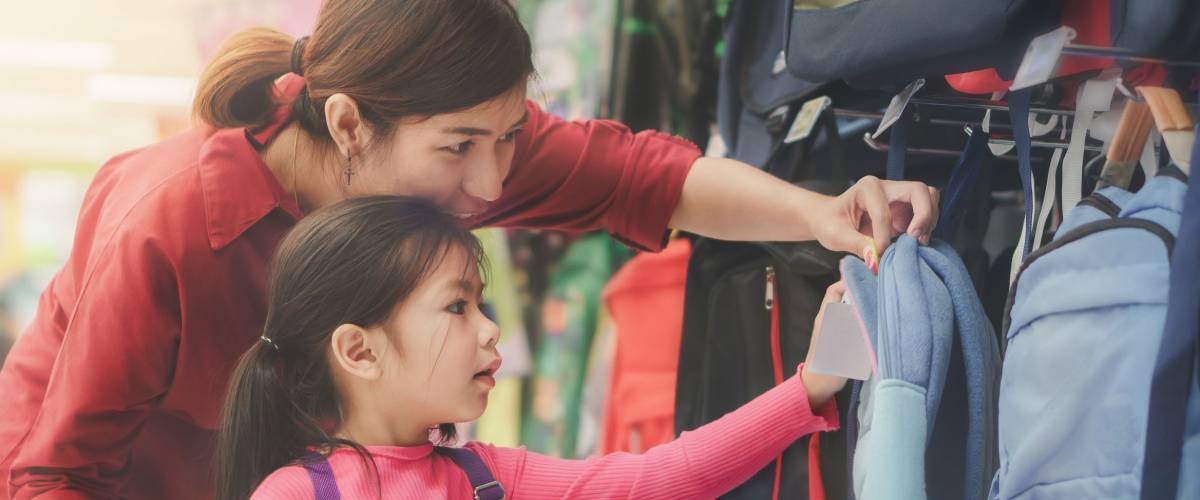 Back to school concept, Young asian mother or parent and little girl kid buying school satchel or bag in store, Selective focus