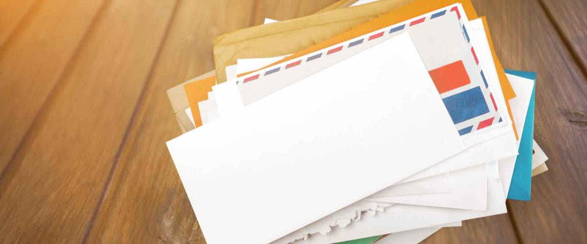 Pile of envelopes with overdue utility bills isolated on white