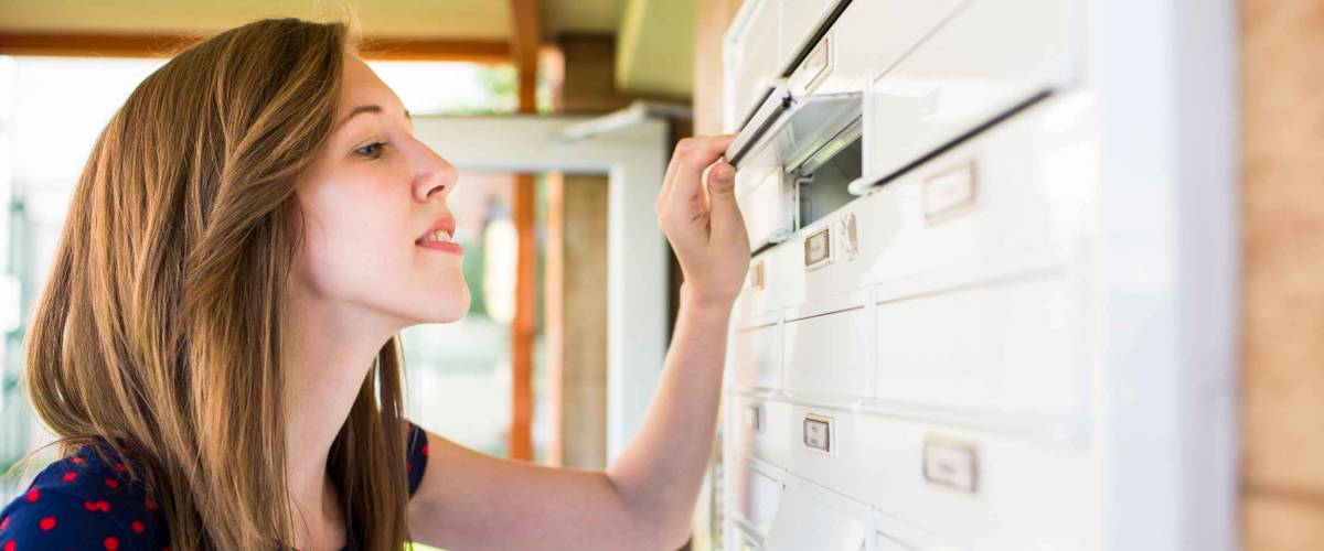 Young woman checking her mailbox for new letters