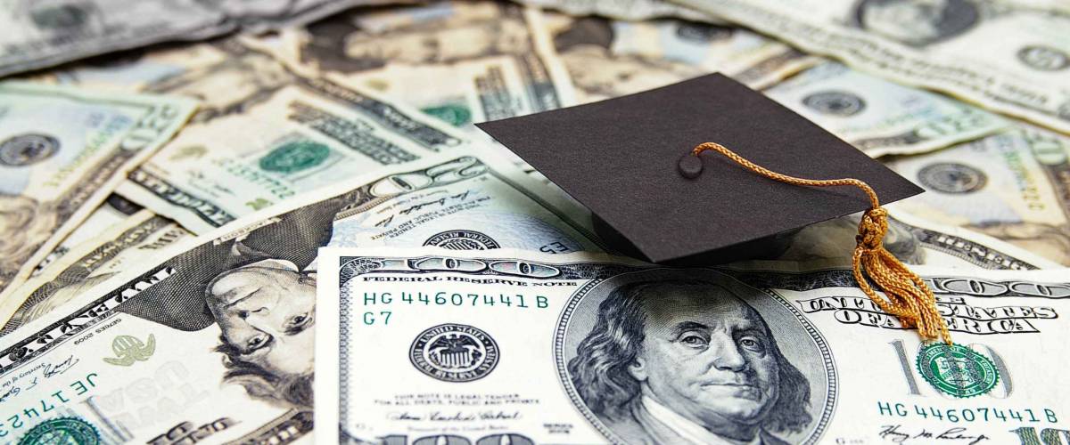 mini graduation cap on US money