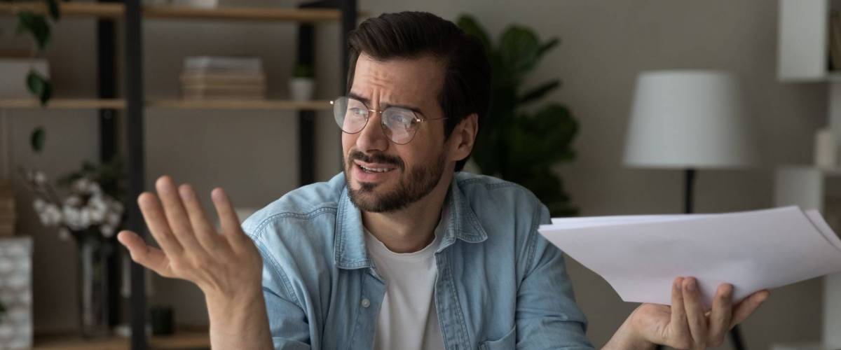 Confused man holding paper