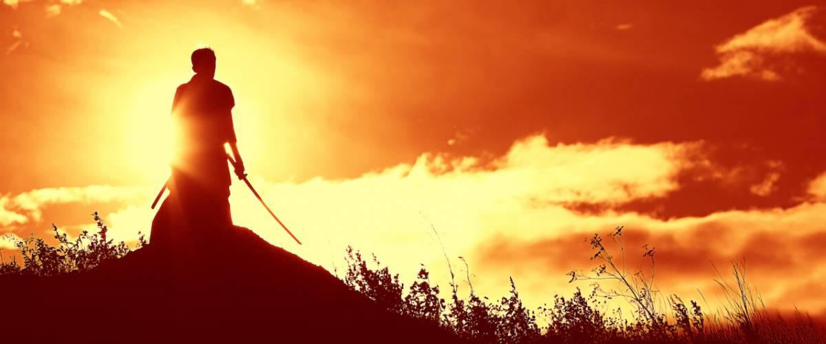 Japanese fighter against sunset holding a sword