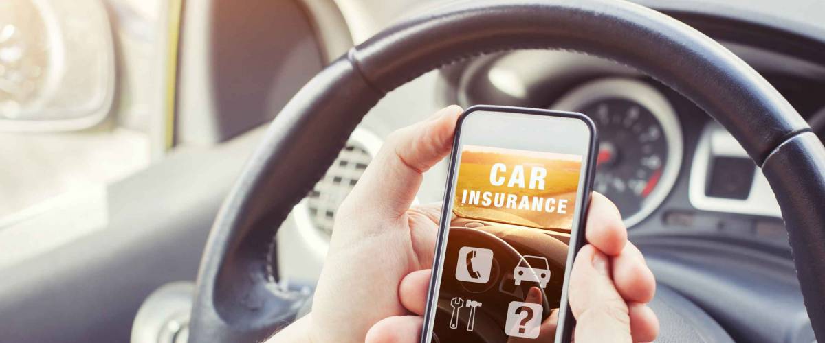 Driver looking at car insurance website on smartphone