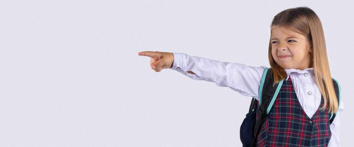 Banner, long format, grey background. Upset schoolgirl pointing her finger to side, away. Serious girl showing exit, asking to leave her alone. Get out, Get off.
