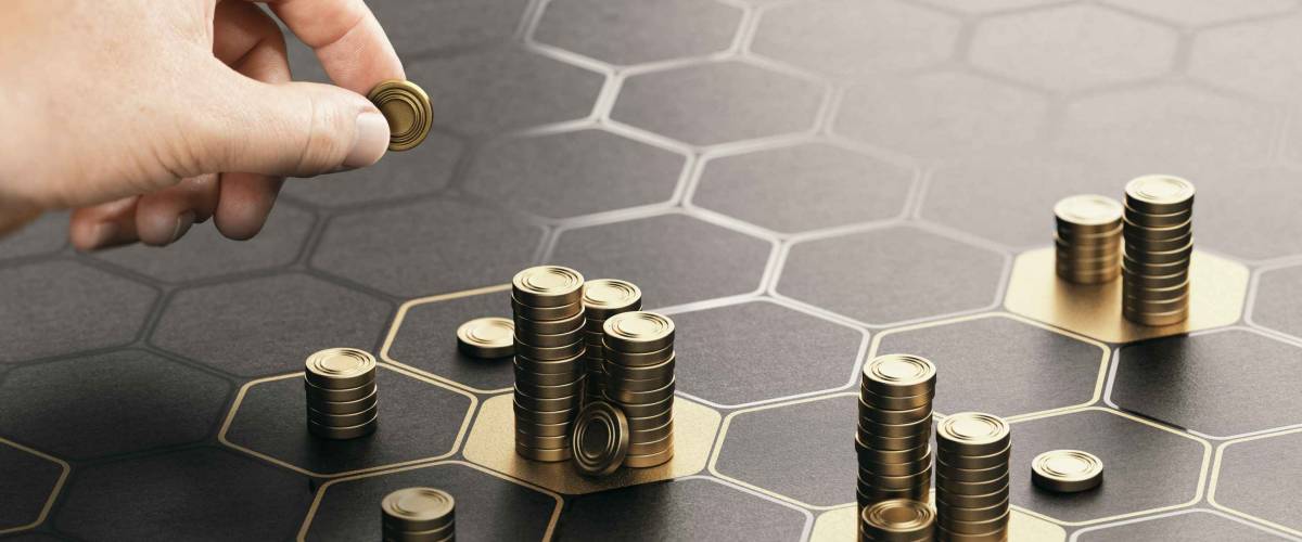 Human hand stacking coins over a black background with hexagonal golden shapes. Concept of investment management and portfolio diversification.