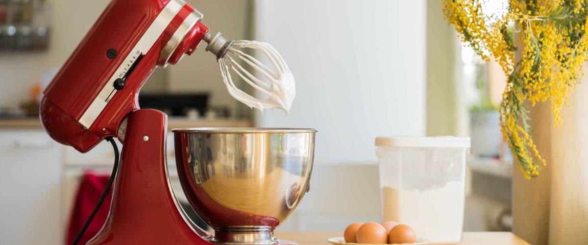 red stand mixer mixing cream