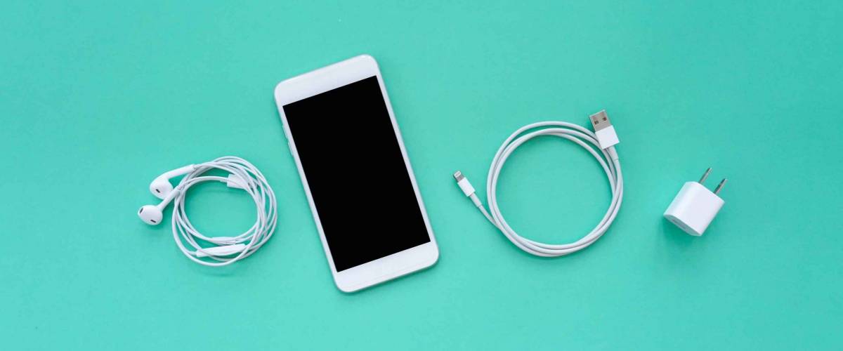 Smartphone, Earphones, Charger, and USB Cable on Turquoise Background Top View