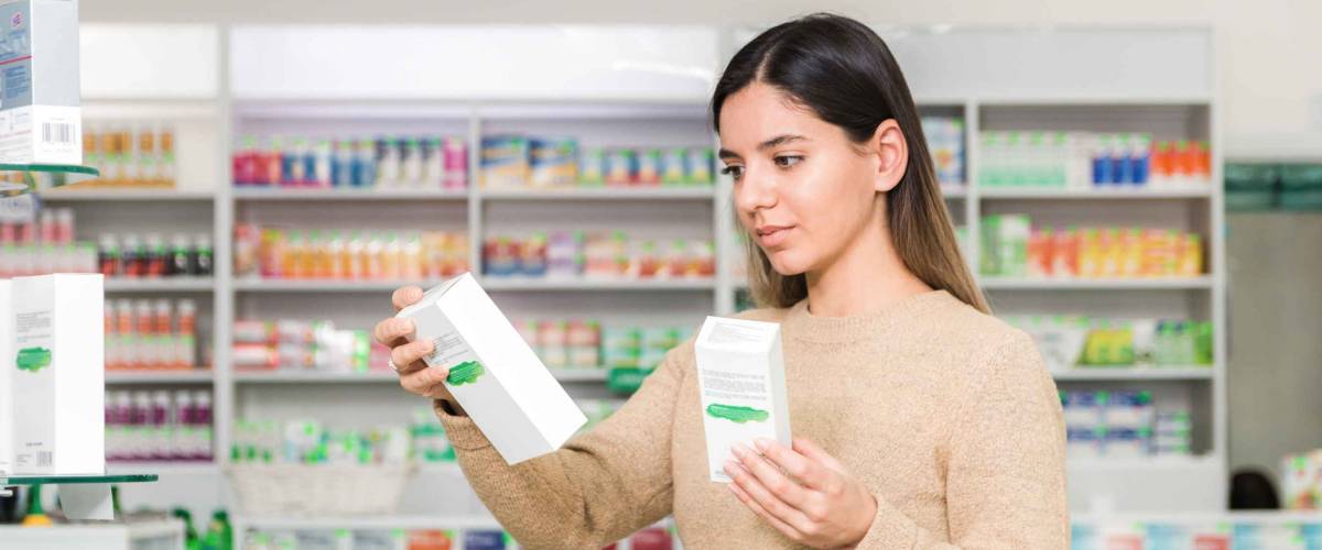 woman choosing vitamins and supplements in a grocery store.