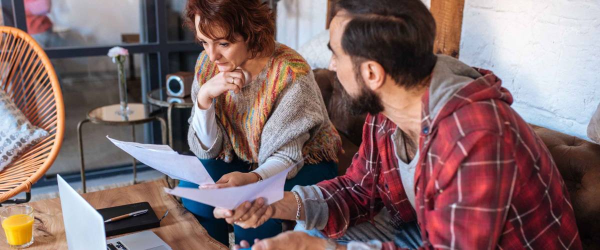 Mature couple sitting at home looking at their finance problems