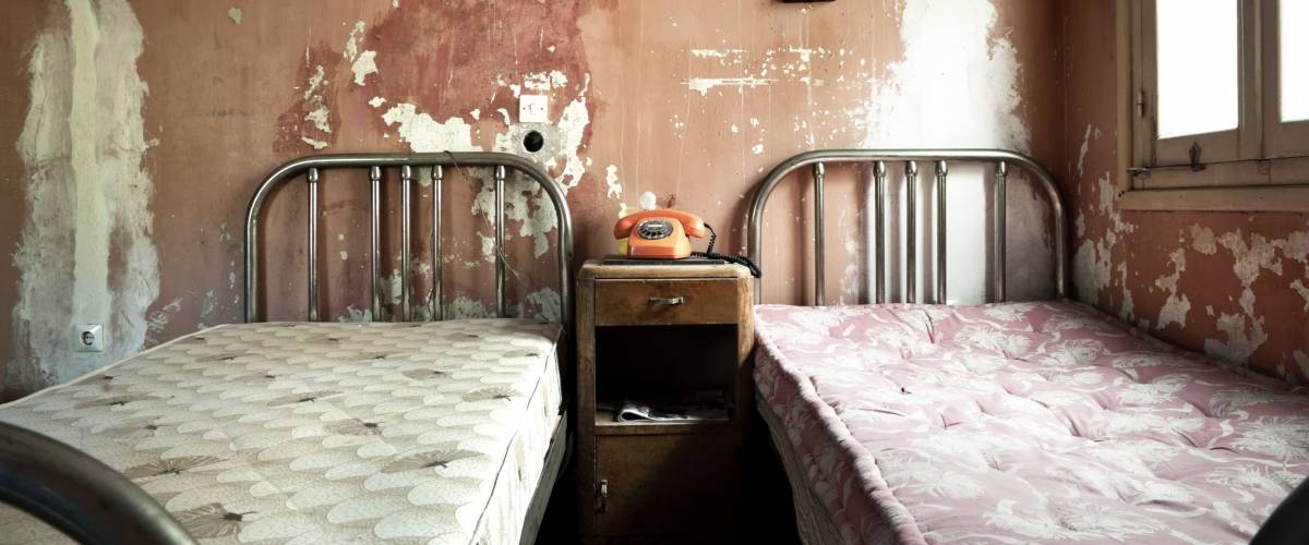 Creepy dirty and abandoned bedroom with cracked walls