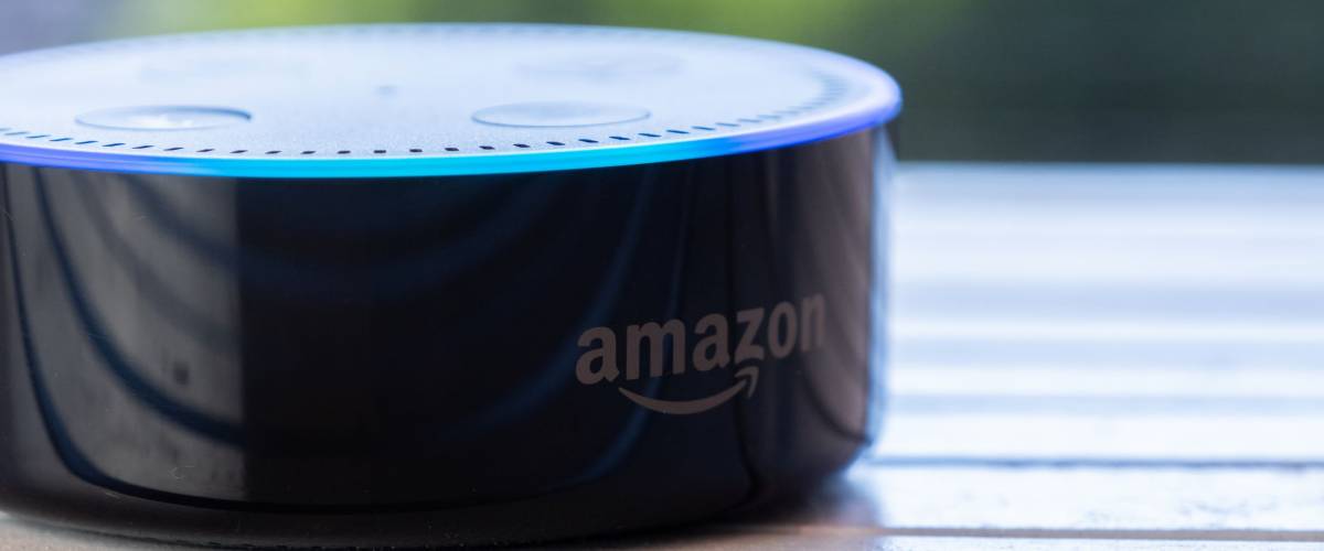 TOKYO, JAPAN - JUNE 28TH, 2018. Amazon's Echo Dot, Alexa virtual assistant on wooden board.