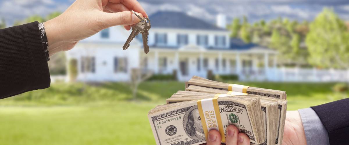 Handing Over Cash For House Keys in Front of Beautiful New Home.