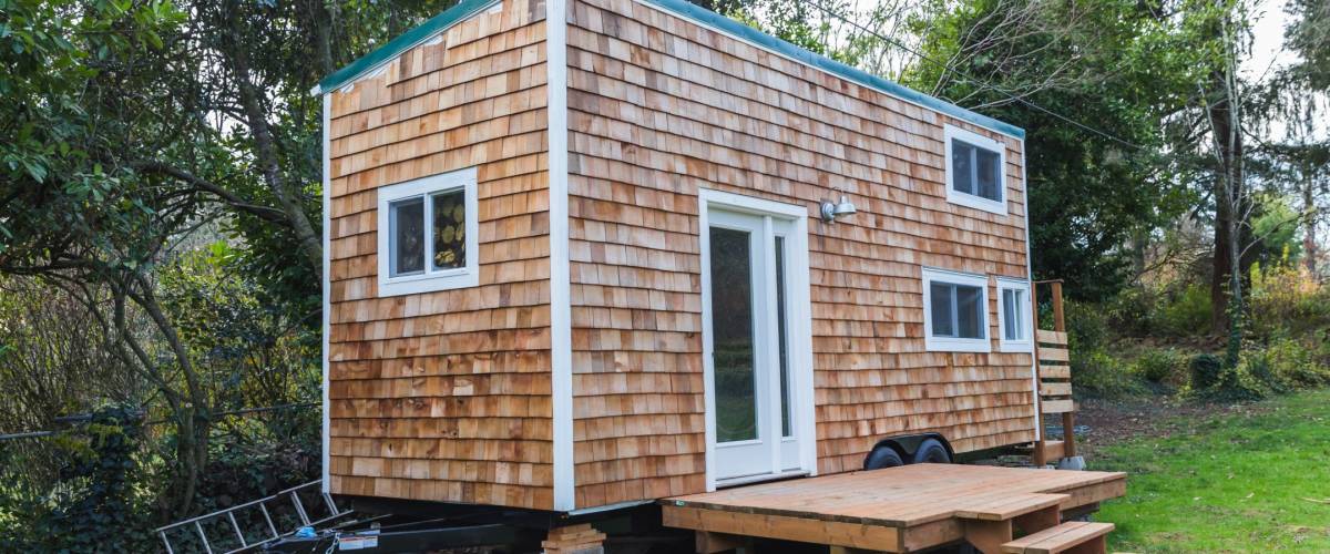 Portable tiny home with wood siding in the back yard of a larger property. Forest Grove, Oregon, USA.