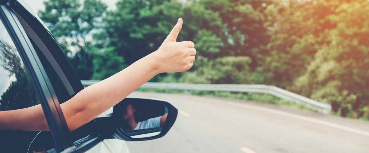 Happy girl traveling in a hatchback car