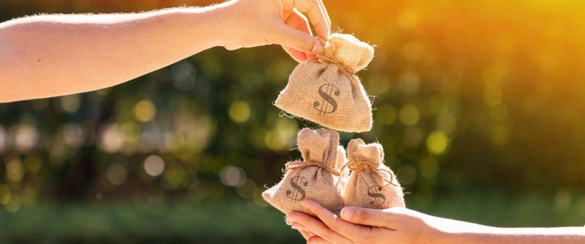 A man and a women hands hold a money bags in the public park for loans to planned investment in the future concept.