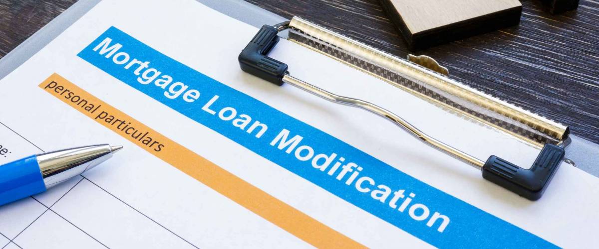 Mortgage loan modification application with pen and notepad.