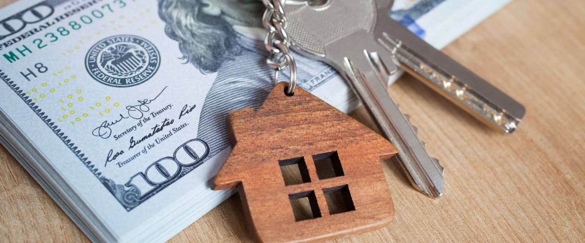 Real estate investing concept. American dollar, cash or housing. Keys close-up
