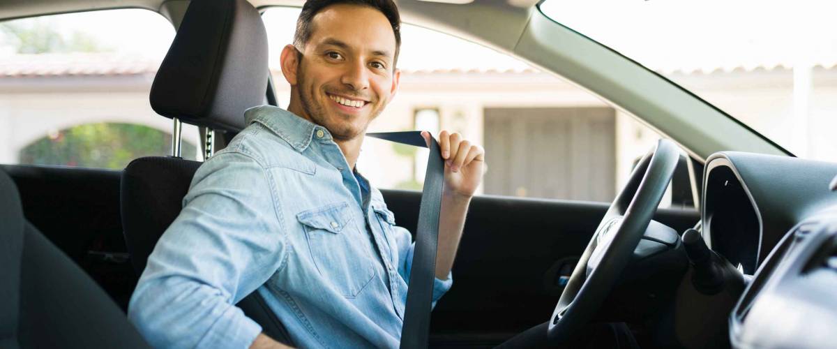 Portrait of an attractive latin man smiling before starting to work as a taxi driver of a car sharing service on a mobile app