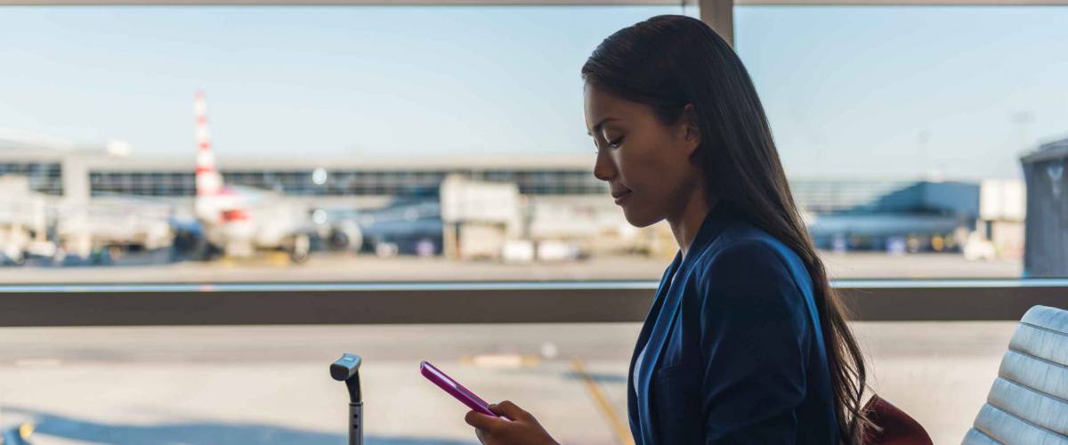 Woman using phone in business class lunge at airport