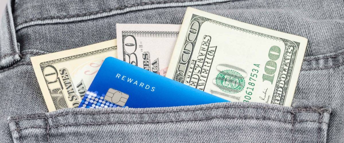 US dollar banknote and credit card in the grey jean pocket