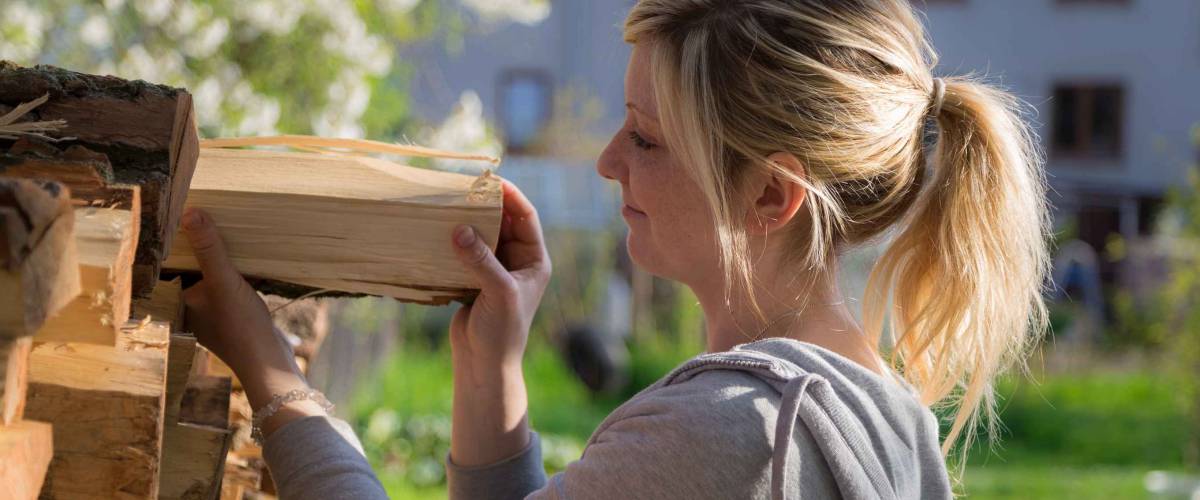 Girl fold wood in the spring garden