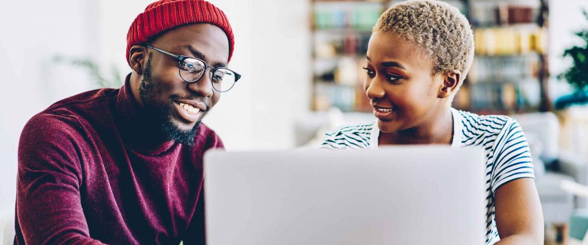 African american couple browse website on laptop computer, looking for low mortgage rates.
