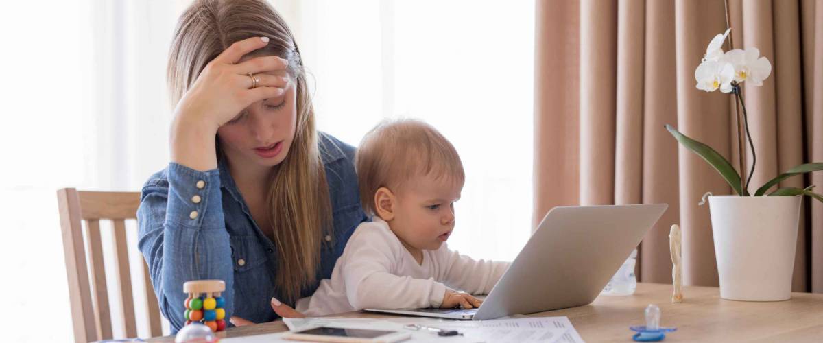 Tired working mom with child in her lap feeling exhausted