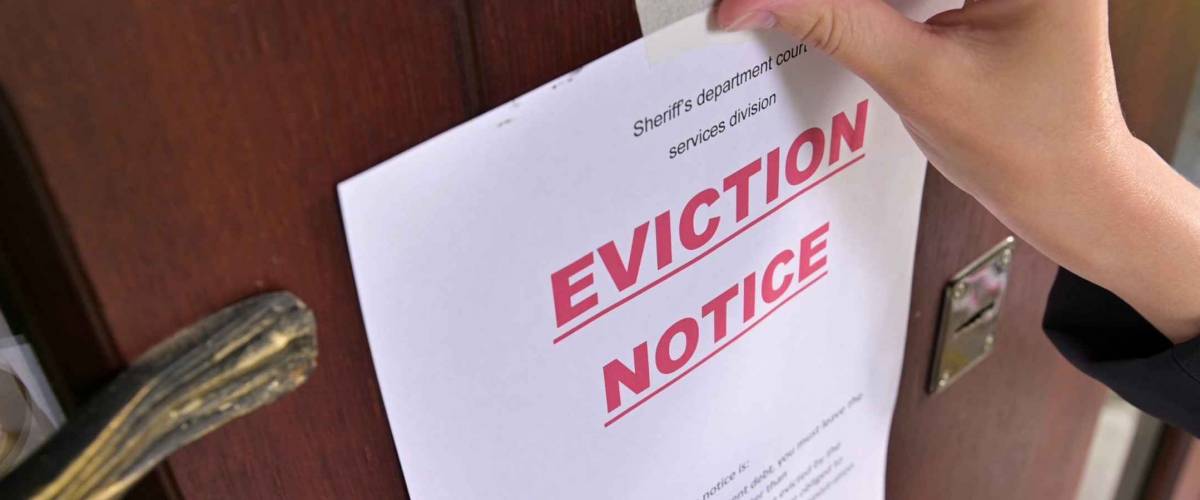 Civil servant sticks a notice of eviction of the tenant, close up