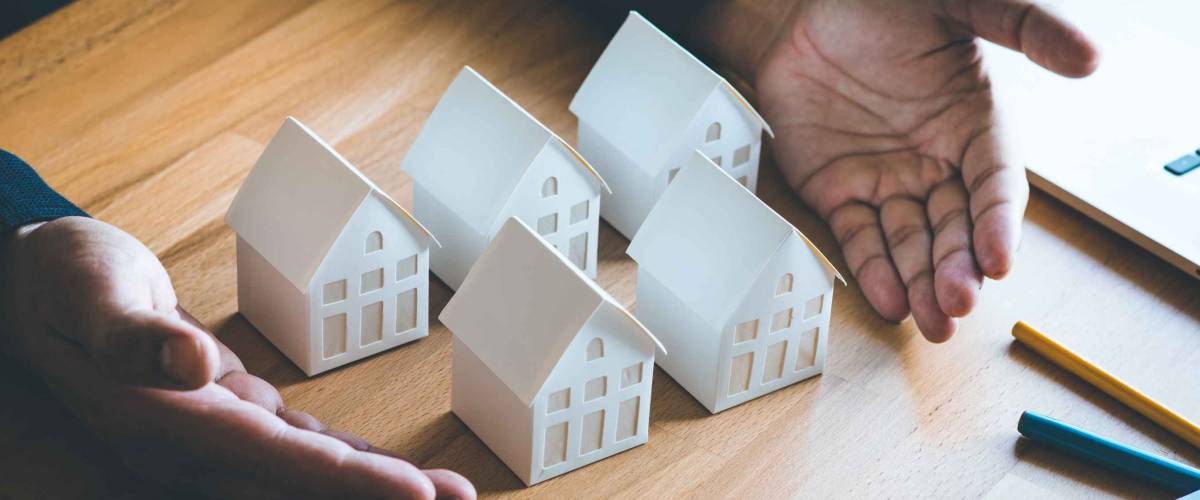 Business property,real estate and investment concepts with investor and white model house on pastel color background.