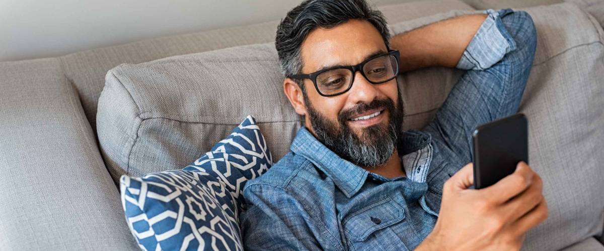 Happy smiling latin man using smartphone device