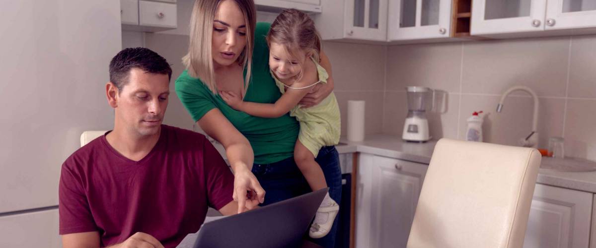 Worried young parent calculating bills at home