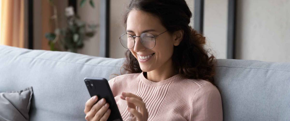Happy millennial woman relaxing on comfortable sofa