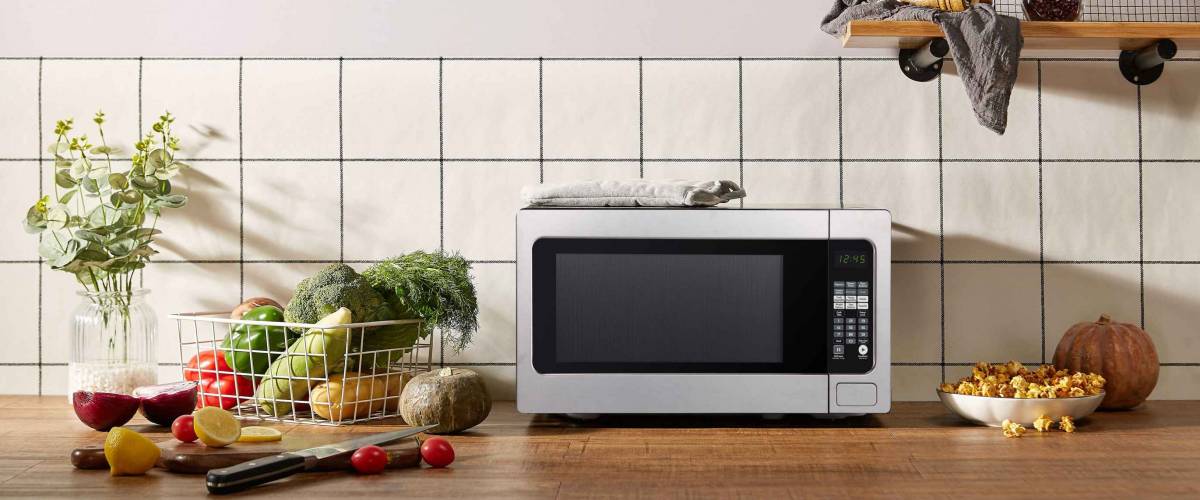 Microwave on kitchen table with vegetables