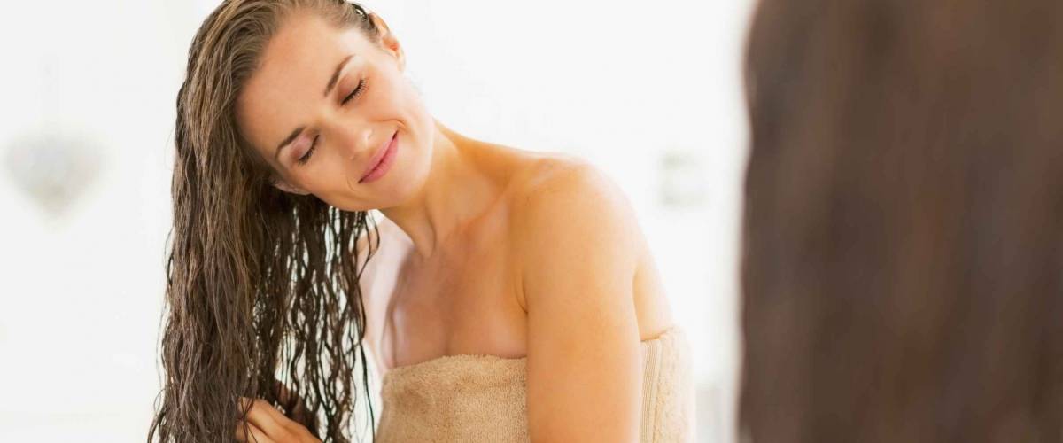 Happy young woman with wet hair in bathroom