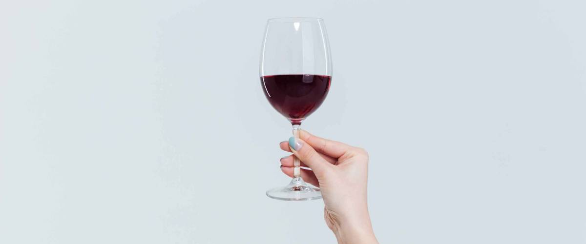 Female hand holding glass with wine isolated on a white background