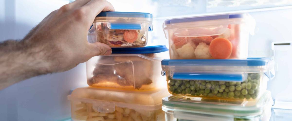 Man's Hand Taking Container Of Frozen Mixed Vegetables From Refrigerator