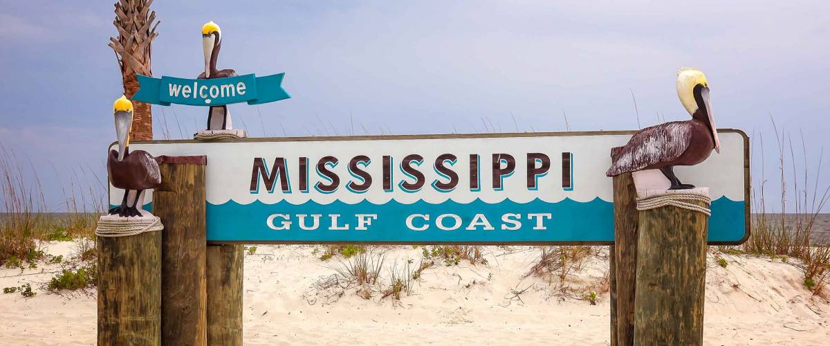 Welcome to Mississippi Gulf Coast sign on sandy beach in Gulfport