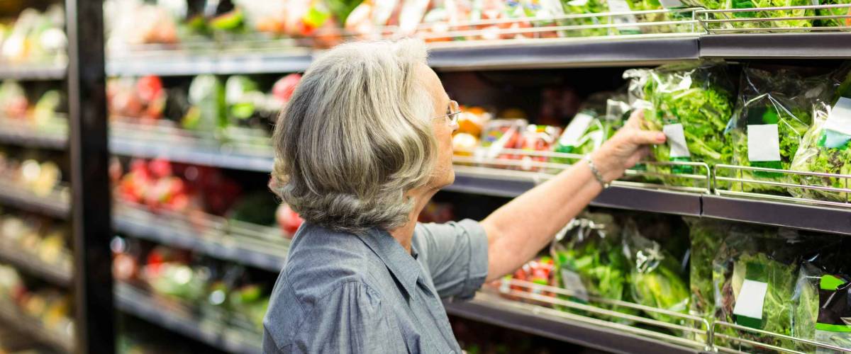 Senior woman picking out some vegetables in supermarket