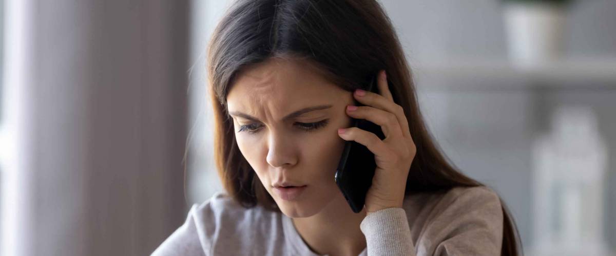 Serious concerned woman talking on phone