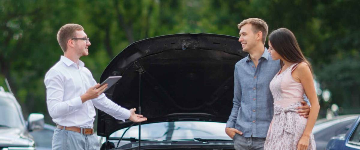 Young couple buying a used car from a dealer.