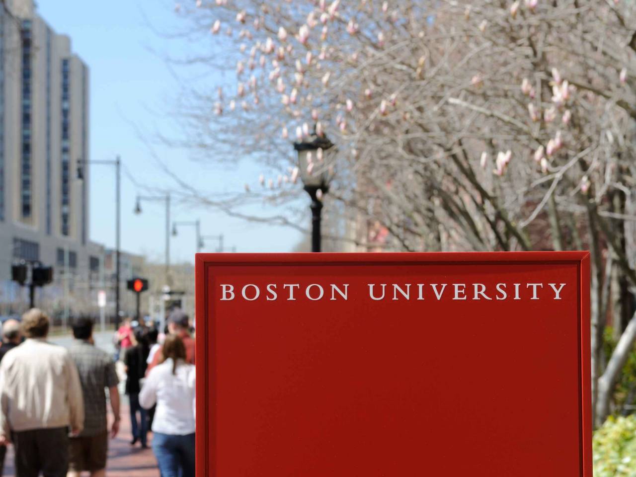 Boston University sign and crowd of students walking by in early spring