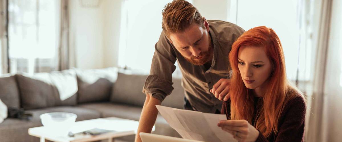 Young couple calculating bills at home.