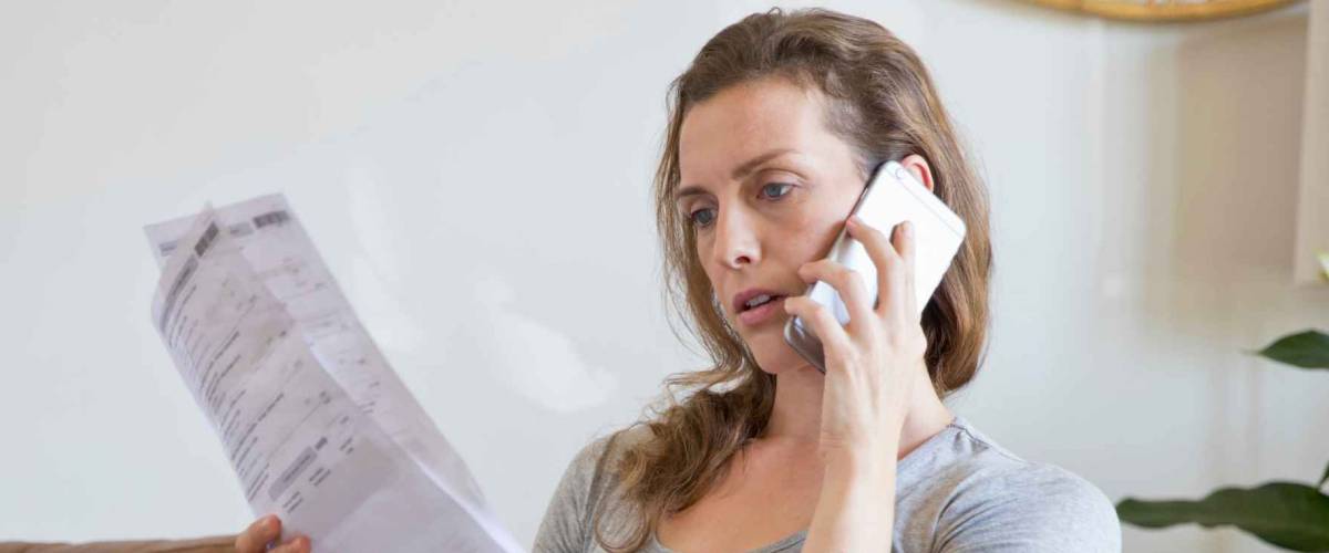 Stressed Mother On Phone With Laptop Looking At Household Bills