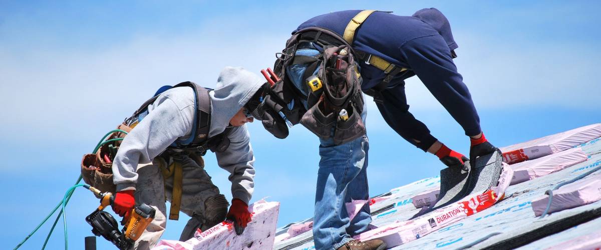 CASPER, WYOMING. MAY 22, 2013. CIRCA: Male roofers at work outdoors on top of a housing project.