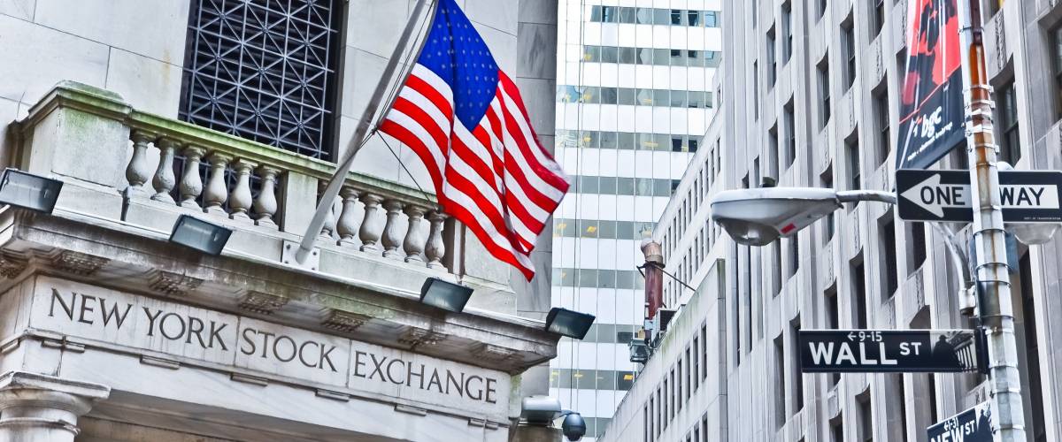 NEW YORK CITY, NY - OCT 11: The side entrance of New York Stock Exchange and a street sign of Wall Street shown on October 11, 2013 in New York City. The Exchange building was built in 1903.