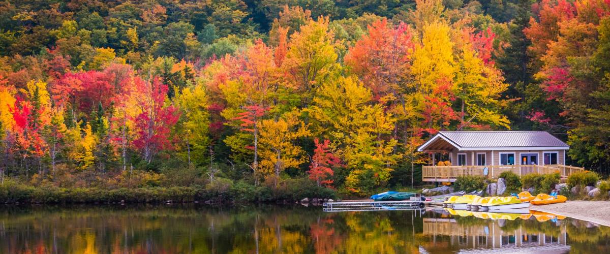 Boathouse and fall colors reflecting in Echo Lake, in Franconia Notch State Park, New Hampshire.