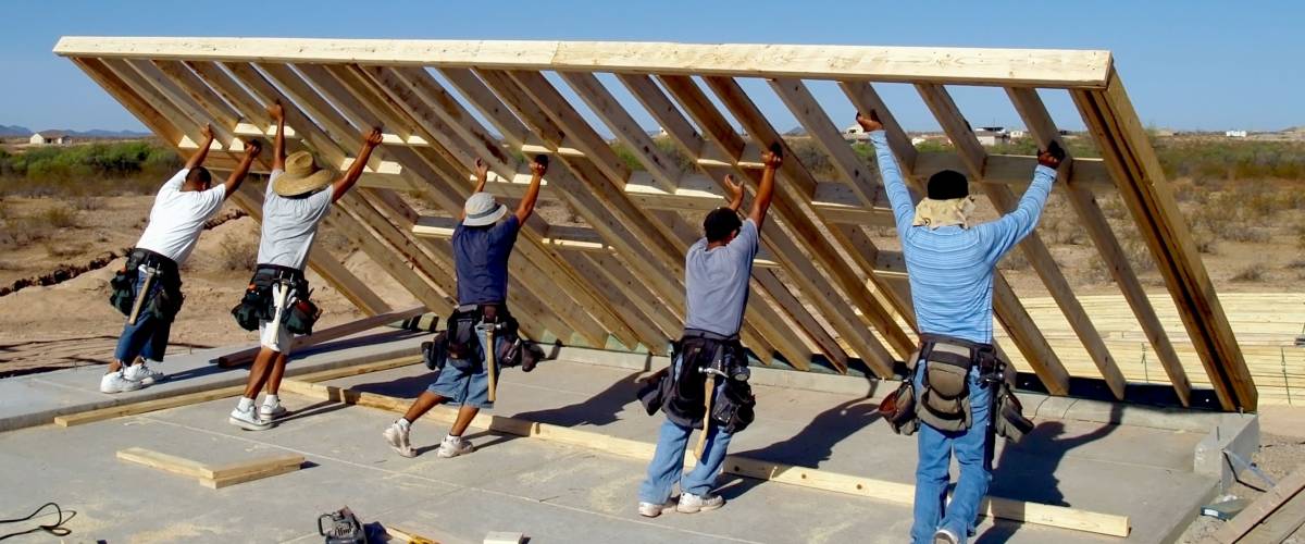 Taken in 2008. A group of construction workers raising a wood frame for a house located in Arizona.